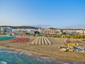 a beach with a bunch of chairs and water at Kriti Beach Hotel in Rethymno Town