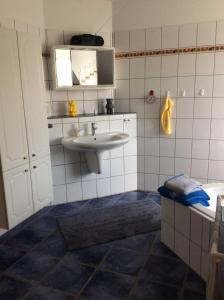 a bathroom with a sink and a toilet and a mirror at Ferienwohnung im Grünen in Sassenberg