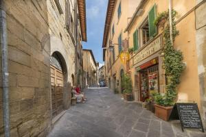 un vicolo in un centro storico con persone sedute su una panchina di I Bei Ricordi - Historic Centre Apartment 6 ad Arezzo