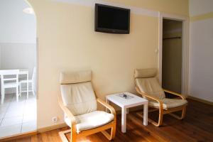 a room with two chairs and a table and a tv at Apartments Kolo 77 in Berlin