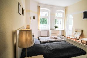 ein Schlafzimmer mit einem Bett mit einer Lampe und einem Stuhl in der Unterkunft Apartments Kolo 77 in Berlin