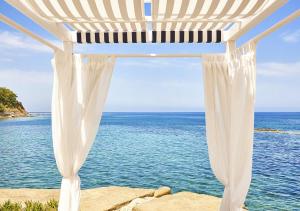 einen weißen Pavillon mit dem Ozean im Hintergrund in der Unterkunft Approdo Resort Thalasso Spa in Castellabate