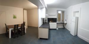 a kitchen and dining room with a table and a refrigerator at La Bourrellerie in Lusigny-sur-Barse
