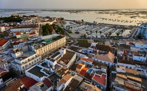an aerial view of a city with a beach at Occidental Faro in Faro