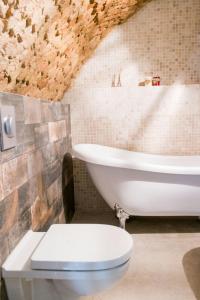 a bathroom with a toilet and a bath tub at Unique Old Town Apartment in Vilnius
