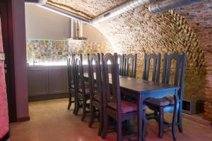 a table and chairs in a room with a brick wall at Unique Old Town Apartment in Vilnius