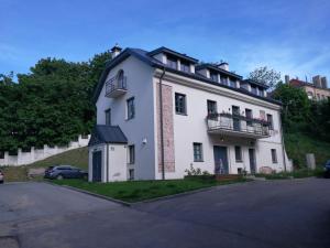 a large white house with a balcony on a hill at Unique Old Town Apartment in Vilnius
