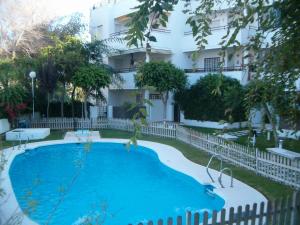 a swimming pool in front of a building at Apartamento Pepi Chipiona in Chipiona