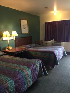 Hudson Plaza Motel Bayonne Jersey City في مدينة جيرسي: غرفة فندقية بسريرين وطاولة بها لمبات