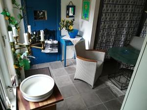een kamer met een tafel en stoelen en een blauwe muur bij Jugendstil-Villa Aerö in Marstal