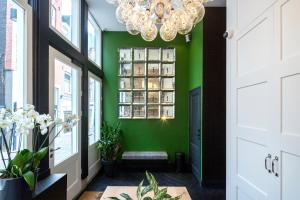 a hallway with green walls and a chandelier at The Highland House in Amsterdam