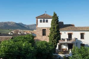 un gran edificio blanco con un árbol delante en Hotel Cortijo del Marqués en Albolote