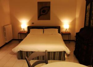 クレモナにあるCremona Appartamento Monolocale Sant'Omobonoのベッドルーム1室(ベッド1台、ランプ2つ、テーブル2台付)