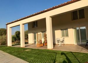 a house with a patio with a table and chairs at Uliwood in Caltanissetta