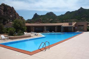 a swimming pool in front of a house with mountains at Villino Elisa in Costa Paradiso