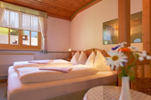 a bedroom with two beds and a table with a vase of flowers at Blasiwirt in Sankt Michael im Lungau