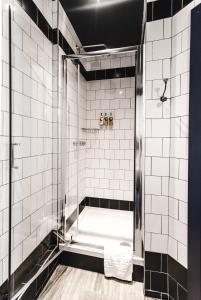 a bathroom with a shower with white tiles at The Waterman in Cambridge