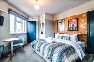 a bedroom with a large bed and a table at The Waterman in Cambridge