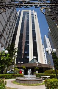 a large building with a fountain in front of it at Le Premier Apartamentos in São Paulo