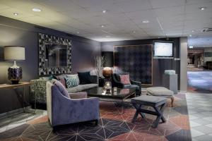 a lobby with a couch and chairs and a tv at Thon Hotel Vettre in Asker