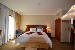 a bedroom with a large bed and a window at Hayah Grand Hotel Ex Al Jaad Madinah Hotel in Medina +32 photos