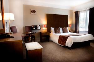 a hotel room with a large bed and a desk at The Gateway Hotel in Swinford