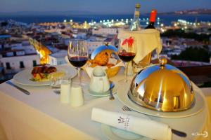 a table with glasses of wine and food on it at Fredj Hotel in Tangier