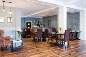 ein Esszimmer mit Tischen und Stühlen und eine Küche in der Unterkunft The Gateway Hotel in Swinford