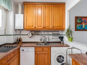 a kitchen with a sink and a washing machine at Apartamento Pepi Chipiona in Chipiona