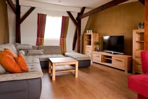 a living room with a couch and a tv at Sonn'Idyll Hotel & Saunalandschaft in Rathenow