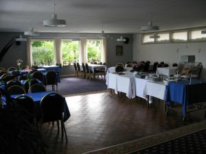 a room full of tables and chairs with blue table cloth at Motel Europa in Svenstrup