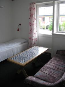 Zimmer mit einem Bett, einem Fenster und einem Tisch in der Unterkunft Motel Europa in Svenstrup