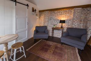 a living room with two chairs and a brick wall at Room 68 in Friedberg