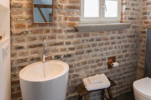 ein Badezimmer mit einem Waschbecken und einer Ziegelwand in der Unterkunft Room 68 in Friedberg