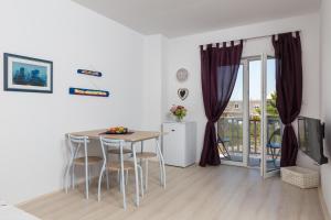 a kitchen and dining room with a table and chairs at Apartman Rokolj in Cavtat