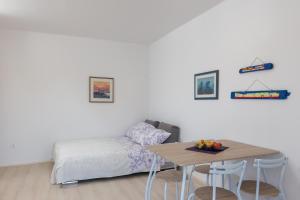 a living room with a bed and a table with a table at Apartman Rokolj in Cavtat