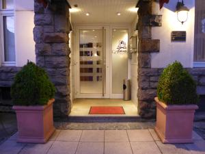 a front door of a house with two potted plants at Astoria Hotel in Ratingen