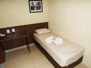 a small room with a bed and a telephone at Downtown Santana Hotel in Rio de Janeiro +30 photos