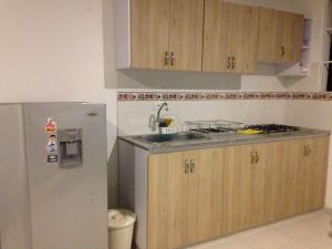 a kitchen with a stainless steel refrigerator and wooden cabinets at Brizzamar Hotel in Santa Marta