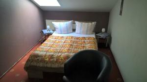 シュテンダールにあるPension-Roexeのベッドルーム1室(ベッド1台、椅子1脚付)