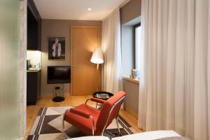 a living room with a red chair and a television at The Guesthouse Vienna in Vienna
