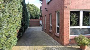 a brick building with a driveway next to a house at Pension-Roexe in Stendal