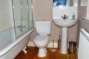 a bathroom with a toilet and a sink and a shower at Teal Cottage in Clachan of Glendaruel