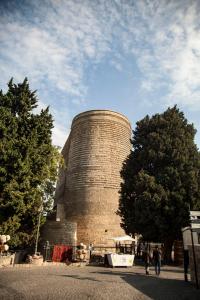 un gran edificio de ladrillo con una torre encima en Cozy Old City Apartment, en Baku