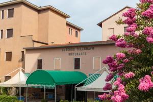 ein Hotel mit rosa Blumen vor einem Gebäude in der Unterkunft Hotel Il Telegrafo in Melegnano