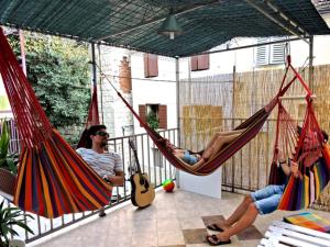 two people are sitting in hammocks on a patio at Hostel Wonderful World in Split