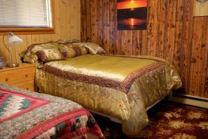 1 Schlafzimmer mit 2 Betten in einem Holzzimmer in der Unterkunft Bluenose Bed & Breakfast in Snow Lake