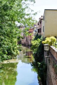 a river in a city with buildings at Casa degli Scacchi in Mantova