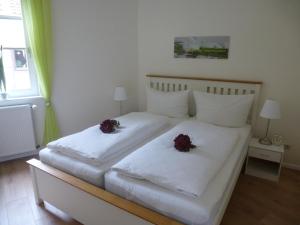 um quarto com duas camas brancas com flores em Ferienwohnungen Braun Goslar em Goslar