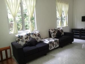 a living room with a couch and a chair at Nas Villaria Langkawi in Pantai Cenang